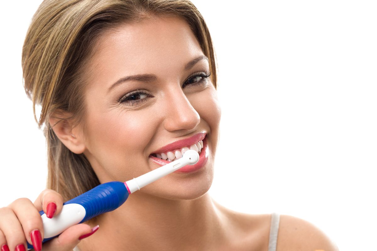 Woman using electric toothbrush