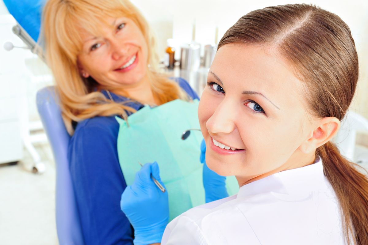 How to Know When You Need a Dental Cleaning Dental hygienist and patient smiling