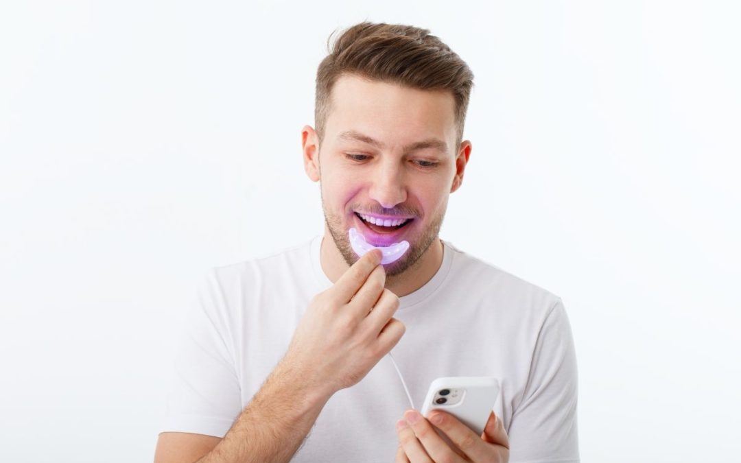 Man using teeth whitening device